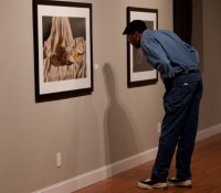 A visitor examines the work